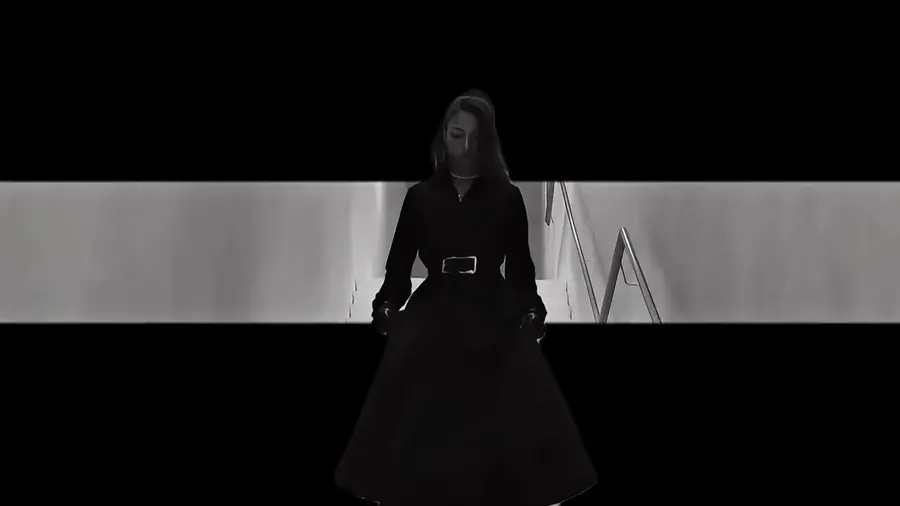 Une silhouette en noir descendant un escalier blanc